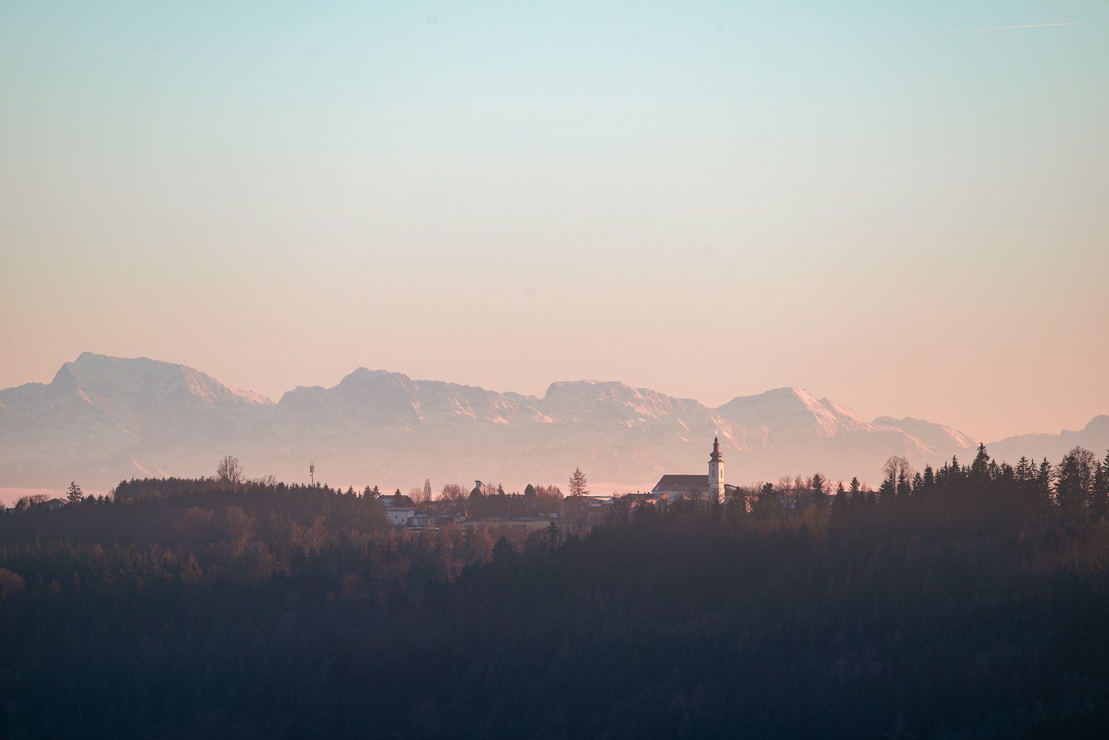 A view of a mountain range with a church in the foreground